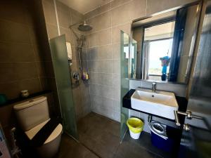 a bathroom with a sink and a toilet and a mirror at LS Tropicana 218*Sea View*1BR*Georgetown*King Bed in George Town +37 photos