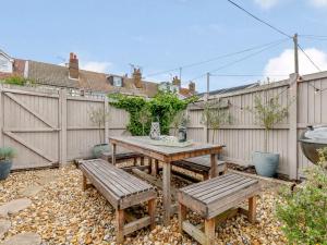 a picnic table and benches in a backyard with a fence at 3 Bed in Whitstable WCC20 in Whitstable
