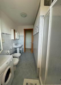La salle de bains est pourvue de 2 toilettes, d'un lavabo et d'une douche. dans l'établissement Leto Apartment, à Letojanni