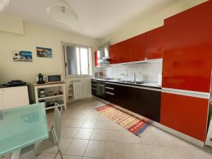 a kitchen with red cabinets and a tile floor at Leto Apartment in Letojanni +16 photos