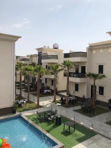 an apartment complex with a swimming pool and palm trees at النخيل رست in Al Shafa