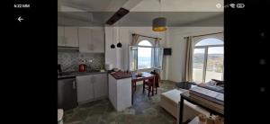 a kitchen and living room with a table and a couch at PALACE Sea view in Megála Khoráfia