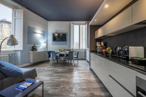 eine Küche und ein Wohnzimmer mit einem Sofa und einem Tisch in der Unterkunft Cherubini Palace Thematic Apartment in Florenz