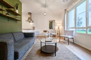 uma sala de estar com um sofá e uma mesa em One bedroom apartment near metro, with parking em Lille