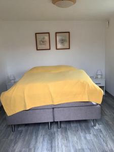 um quarto com uma cama com um cobertor amarelo em Skönaste stället som finns. Bara 300 m till havet. em Lysekil