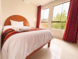a bedroom with a bed and a large window at La Mansion Casa Hotel in Andahuaylas