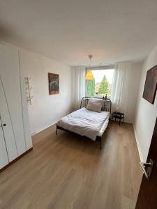 1 dormitorio con cama y ventana grande en geräumige Ferienwohnung Emsaue, en Rheine