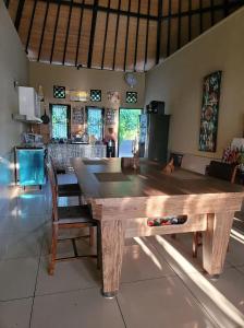 a wooden table in a kitchen with a dining room at Villa Aurora Lovina in Lovina +3 photos