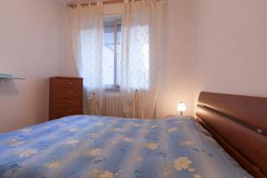 - une chambre avec un lit doté d'une couette bleue et d'une fenêtre dans l'établissement Appartamento BC, à Follonica