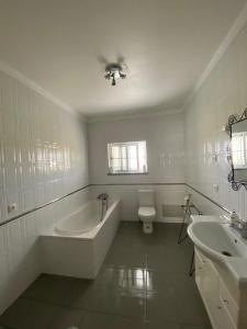 een badkamer met een bad, een toilet en een wastafel bij Quinta Da Amoreira in Ferreira do Alentejo
