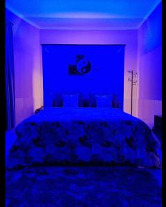 a bedroom with a bed with blue and purple lighting at Villa Aurora Lovina in Lovina