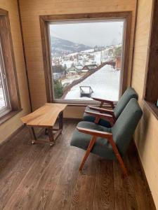 スラブスクにあるfazenda slavskoの椅子とテーブル、窓が備わる客室です。