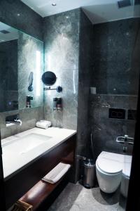 a bathroom with a white sink and a toilet at peninsula the boutique hotel in Panchkula