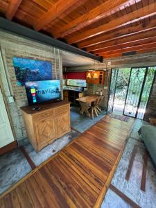 a living room with a tv and a wooden floor at Cabañas Arehue in Mar del Plata