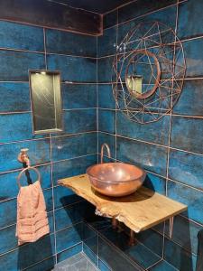 - une salle de bains avec un bol en cuivre sur une étagère en bois dans l'établissement River Avon Retreat - A Rustic Gem On The Riverbank, à Fordingbridge