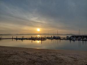 a sunset over a dock with boats in the water at Casita en la playa in Boiro