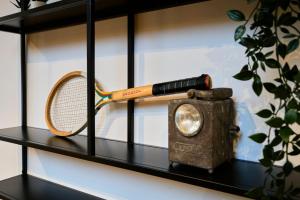 uma raquete de ténis e um livro numa prateleira em Renovated two-bedroom loft veranda em Tourcoing