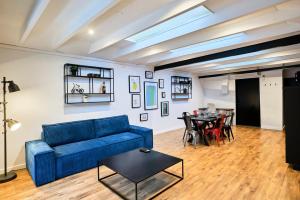 Una sala de estar con un sofá azul y una mesa. en Renovated two-bedroom loft veranda, en Tourcoing 54 fotos más