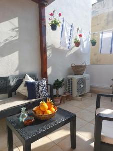 ein Zimmer mit einem Tisch und einer Schüssel Orangen darauf in der Unterkunft Casa Curu in Sciacca