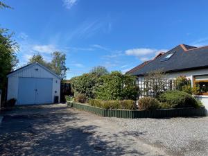 a house with a white garage and a driveway at 26 Green Drive Inverness in Inshes