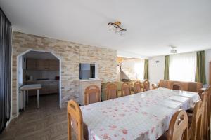a dining room and kitchen with a table and chairs at CASUTA LANGA LAC in Colibiţa