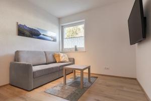 a living room with a couch and a table at Apart Tiroler Huamatli in Schönwies