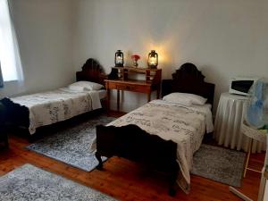 a room with two beds and a table with a desk at Cathy's Guest House in Cradock