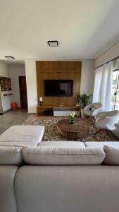 Il comprend un salon doté d'un canapé et d'une télévision à écran plat. dans l'établissement Casa No Ninho, à Porangaba