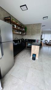 Il comprend une grande cuisine équipée d'un réfrigérateur en acier inoxydable. dans l'établissement Casa No Ninho, à Porangaba