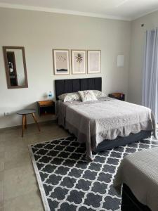 - une chambre avec un grand lit et un tapis dans l'établissement Casa No Ninho, à Porangaba