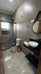 La salle de bains est pourvue de toilettes, d'un lavabo et d'un miroir. dans l'établissement Casa No Ninho, à Porangaba