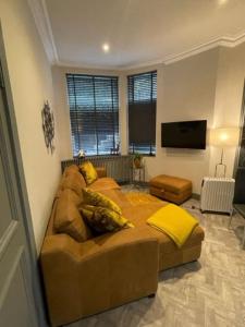 a living room with a couch and a flat screen tv at Complete City Centre Comfort in Edinburgh