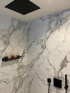 a bathroom with a marble shower with two bottles on a shelf at Complete City Centre Comfort in Edinburgh