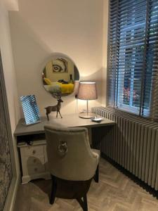a desk with a chair and a lamp and a mirror at Complete City Centre Comfort in Edinburgh