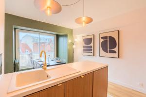 eine Küche mit einem Waschbecken und einem Fenster in der Unterkunft 3 bedroom apartment on the Grand Place in Lille