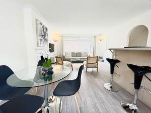 uma sala de estar com uma mesa de vidro e cadeiras em Mayfair - Split Level 2 Bed Apartment em Londres