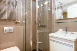 een badkamer met een douche, een toilet en een wastafel bij Skirama 015 in Verbier