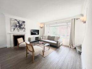 a living room with a couch and a fireplace at Mayfair - Split Level 2 Bed Apartment in London