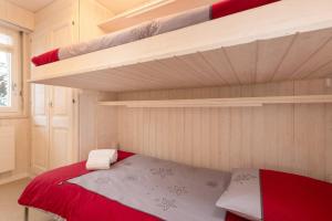 een slaapkamer met 2 stapelbedden en een rood-wit bed bij Skirama 015 in Verbier