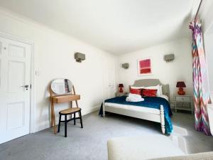 a bedroom with a bed and a chair at Mayfair - Split Level 2 Bed Apartment in London
