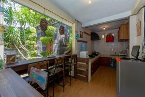 a kitchen with a table and a large window at Cove Raddeyapa in Canggu