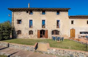 a large stone building with a yard in front of it at Aiguabella - Allotjaments Rurals in Sant Feliu de Pallerols