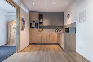 a kitchen with wooden cabinets and a wooden floor at Apart Tiroler Huamatli in Schönwies