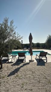 a group of picnic tables and an umbrella next to a pool at NOTO country farm house in Noto