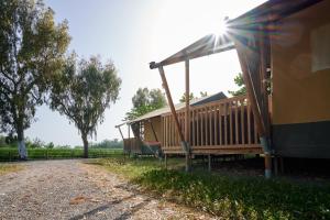 a house with a porch on the side of a field at Glamping Costa Brava in Fortiá