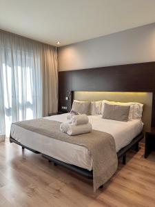 1 dormitorio con 1 cama grande y toallas. en Hotel Tent Granada, en Granada