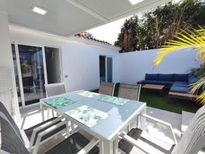 a patio with a table and chairs and a couch at Bungalow BAHIA VERDE in Playa del Ingles