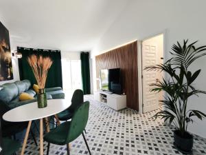 a living room with a couch and a table and a tv at Bungalow BAHIA VERDE in Playa del Ingles
