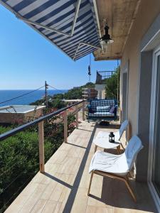 een patio met een tafel en stoelen op een balkon bij SunnyDay House in Masline