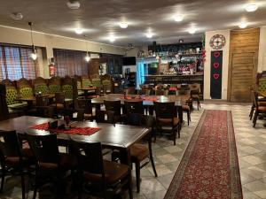 um restaurante com mesas e cadeiras e um bar em Penzión ZOO Pod Hrešnou em Kavečany